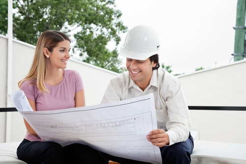 Young female client discussing house plan with male architect